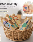 Wooden baby blocks with colorful animal and geometric illustrations arranged in a woven wicker basket. Text on the image highlights material safety, smooth edges, and natural solid wood.