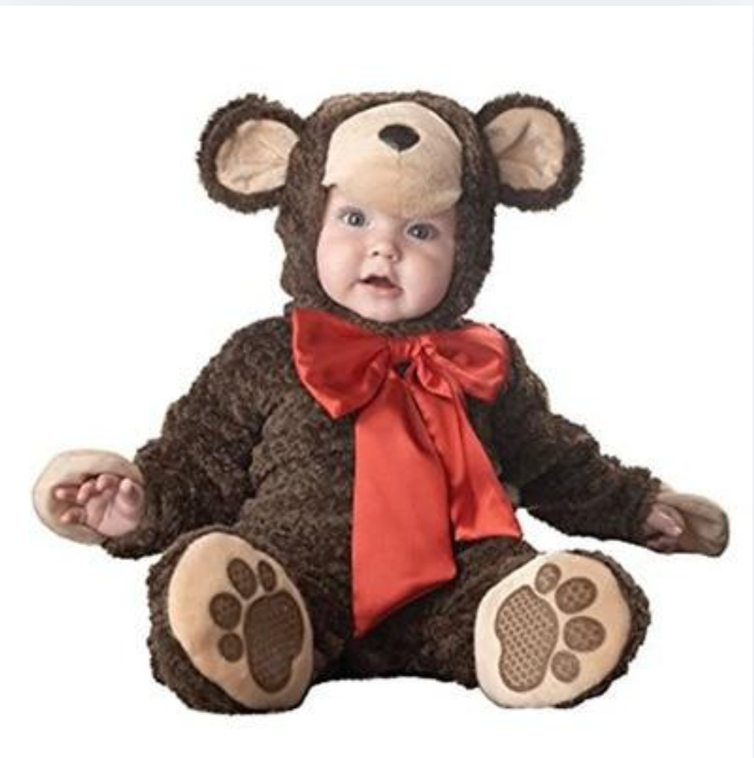 A baby wearing a plush brown teddy bear costume with a beige snout and ears, a red satin bow, and brown paw-print details on the feet, photographed against a plain white background.