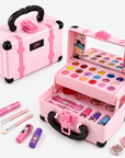 Pink toy makeup case set shown open and closed on a white background, with makeup accessories including lip gloss tubes, brushes, and small jars arranged around it.