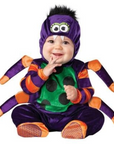 A baby wearing a purple and orange spider costume, sitting against a plain white background.