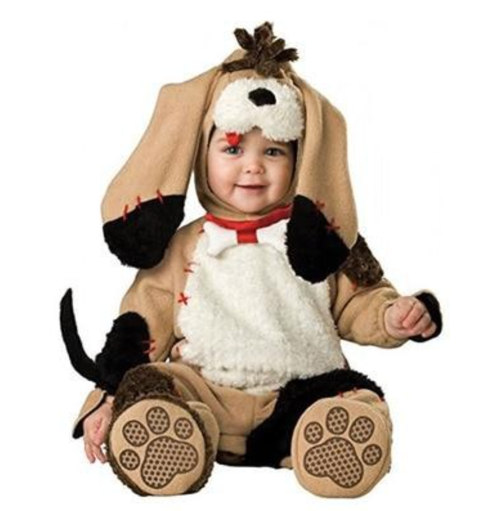 A baby wearing a plush dog costume, featuring a tan hood with long floppy dog ears, a white faux-fur chest panel, black paw pads, and a red collar, photographed against a plain white background.