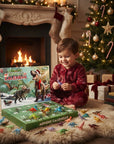 A young child in red pajamas sits on a fluffy rug in a cozy holiday living room, smiling while playing with a dinosaur advent calendar and small dinosaur figures. A lit fireplace, stockings, and a decorated Christmas tree are visible in the background.