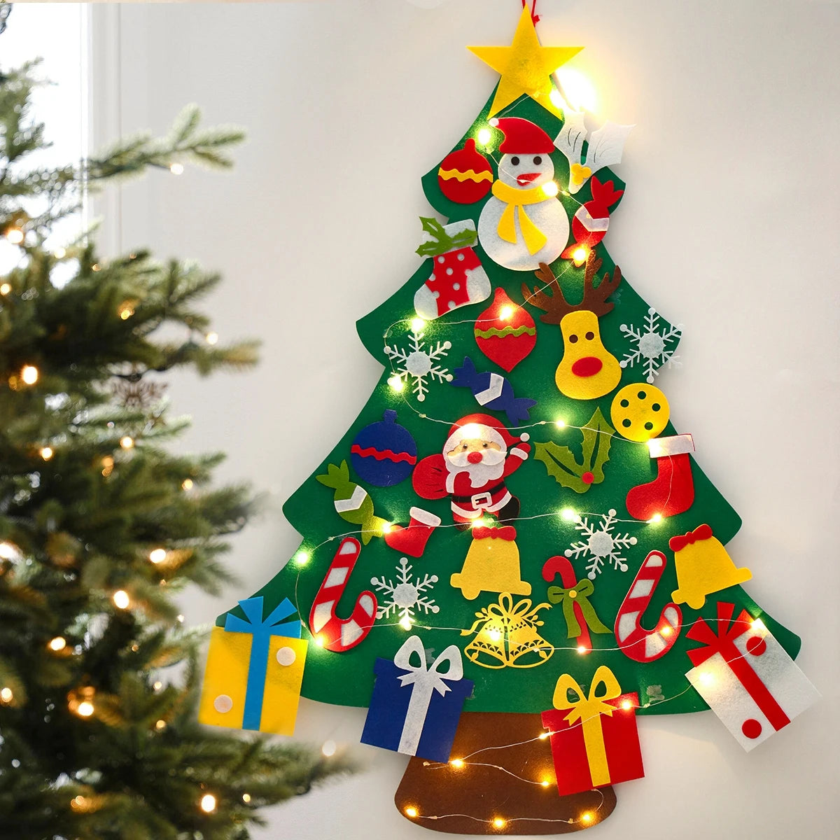 Decorative Christmas tree with lights and ornaments on a white wall.