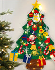 Decorative Christmas tree with lights and ornaments on a white wall.