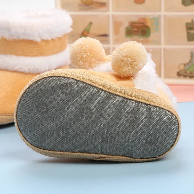 Close-up of a plush toy resembling a cake with a textured gray sole on a light blue surface.