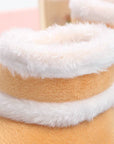 Close-up of a plush toy with white fur trim on a pink background