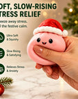 A hand squeezes a pink stress relief squishy toy with a smiling face and a red Santa hat, with promotional text on the left and a softly blurred holiday background.